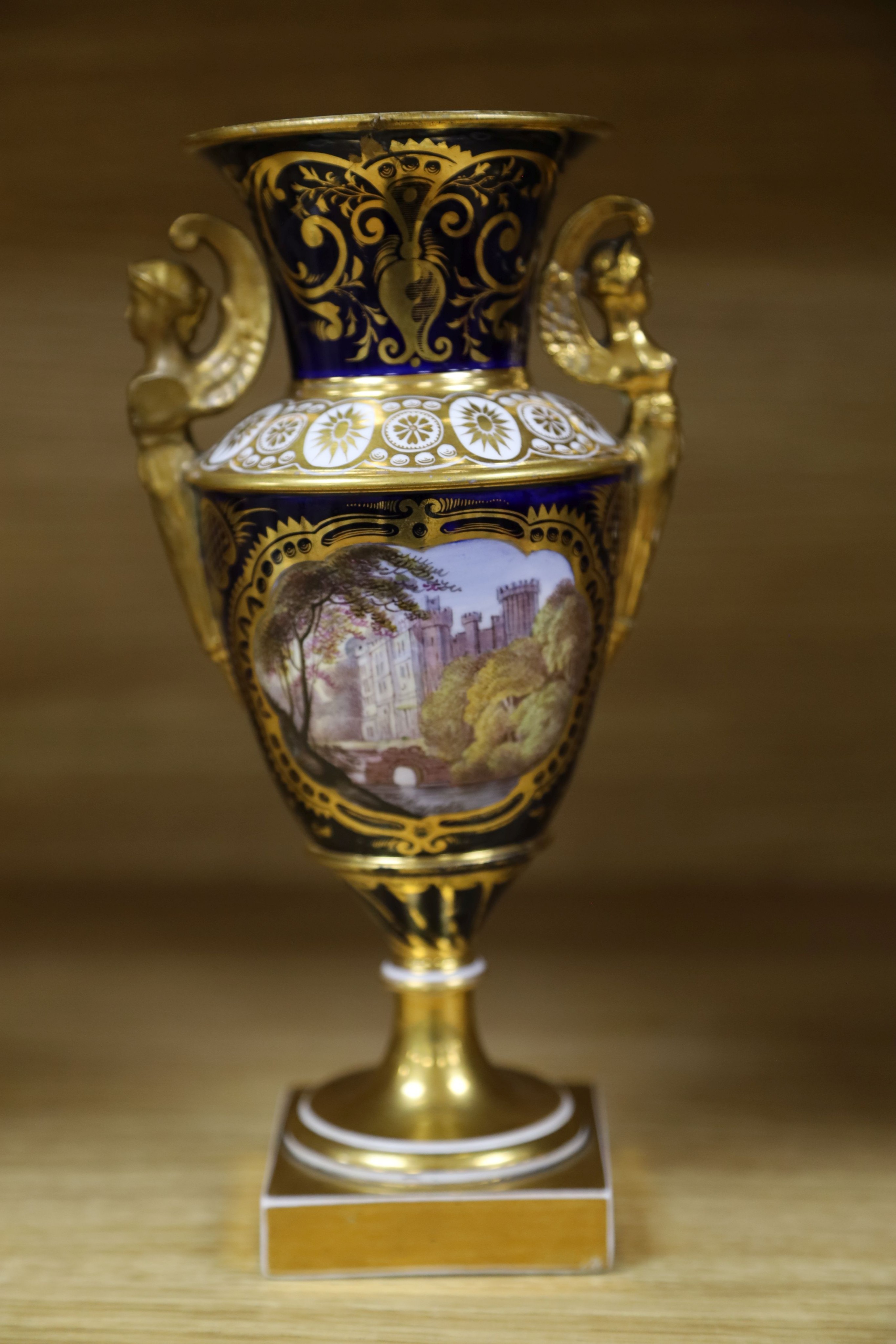 A garniture of three early 19th century English porcelain vases, c.1815-20, each painted with topographical views, tallest 26cm